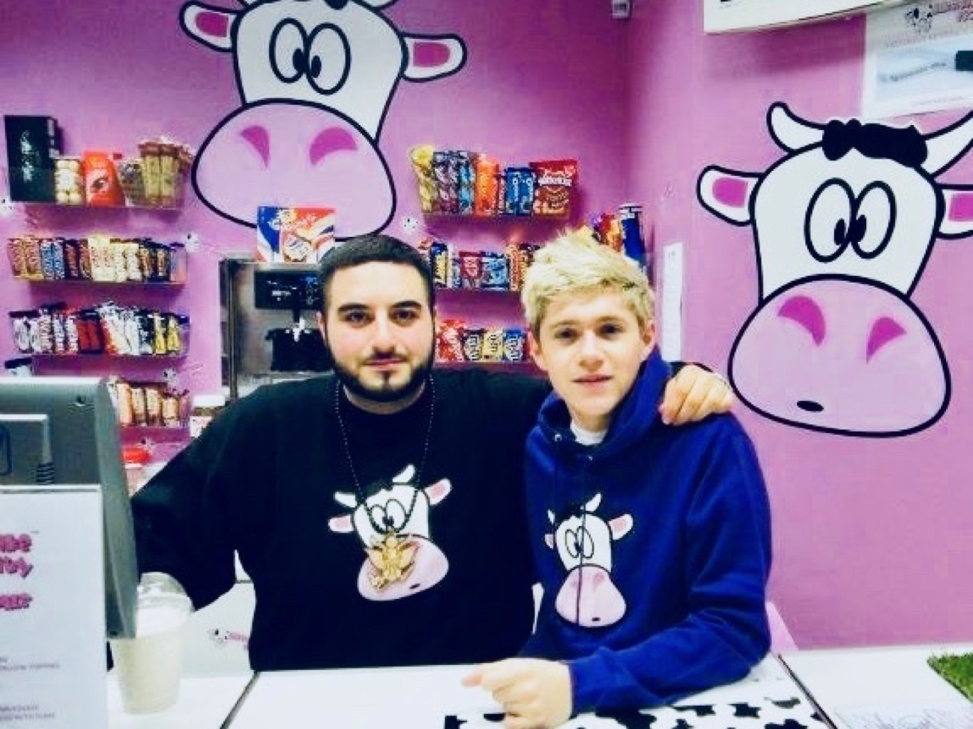 Niall Horan in a Milkshake City hoodie at the counter with a member of staff